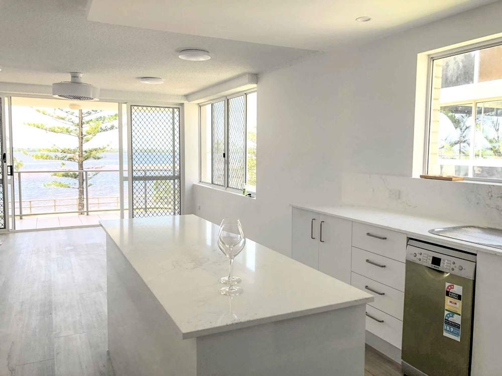 Empty Kitchen White White Counter Top Island — Nyblad Construction in Caloundra West, QLD