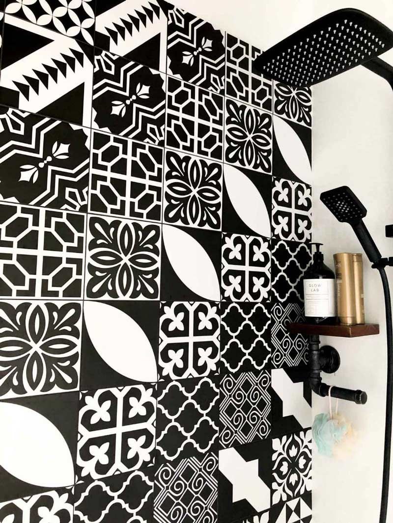 A Bathroom With Black And White Tiles And A Shower Head — Nyblad Construction in Caloundra West, QLD