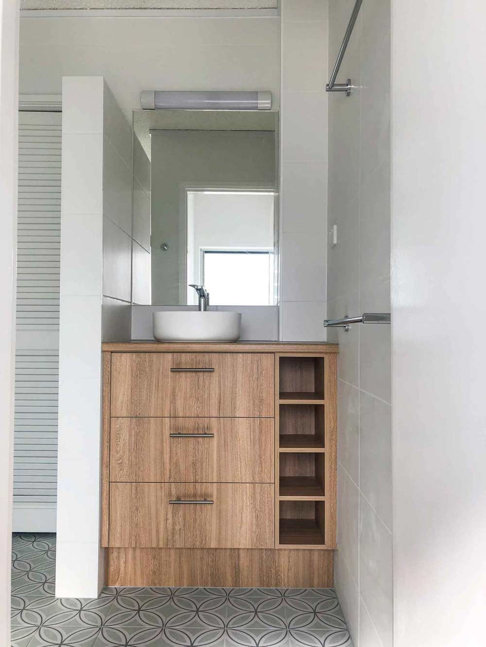 A Bathroom Featuring A Small Cabinet With Sink And Mirror — Nyblad Construction in Caloundra West, QLD