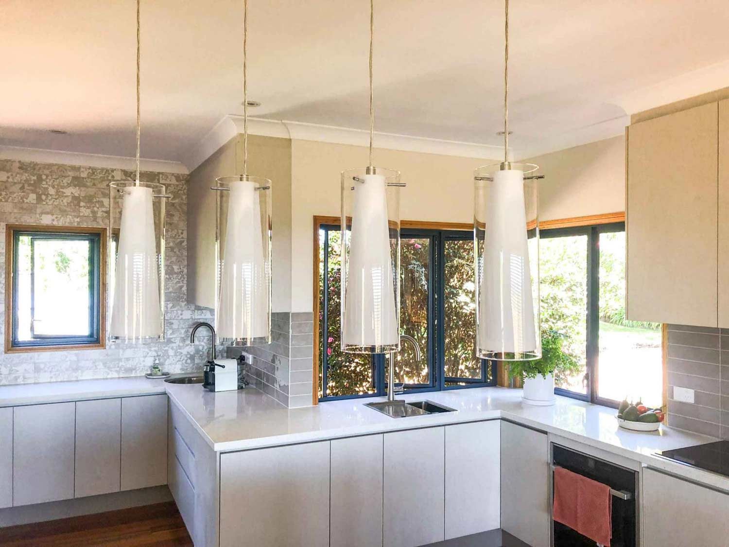 A Kitchen With White Cabinets With Four Lights — Nyblad Construction in Caloundra West, QLD