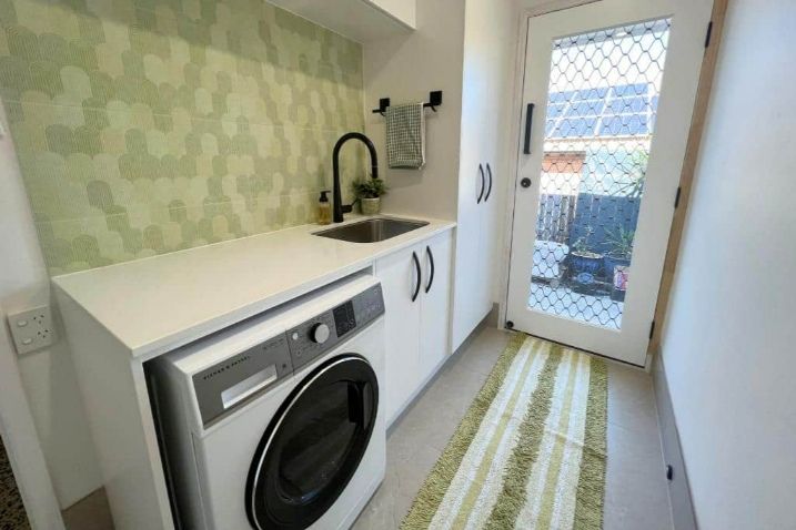 A Laundry Room With A Washing Machine, Sink, And Door — Nyblad Construction in Caloundra West, QLD