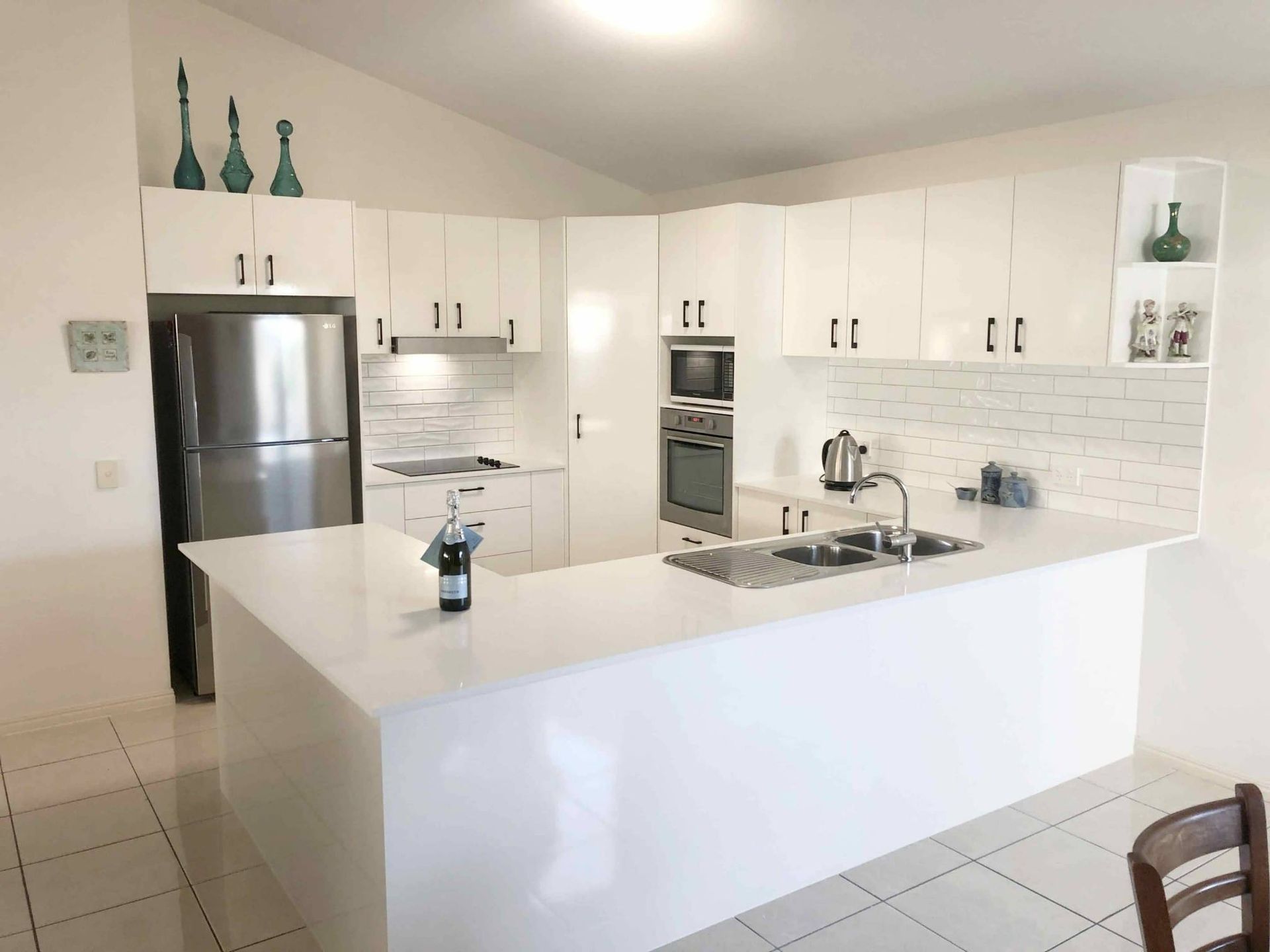  Kitchen Designed With Stainless Steel Appliances, White Cabinets — Nyblad Construction in Caloundra West, QLD