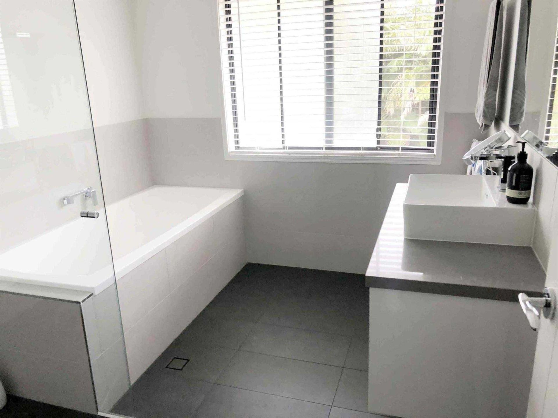 A Bathroom With A Bathtub, Sink, Mirror And Window — Nyblad Construction in Caloundra West, QLD