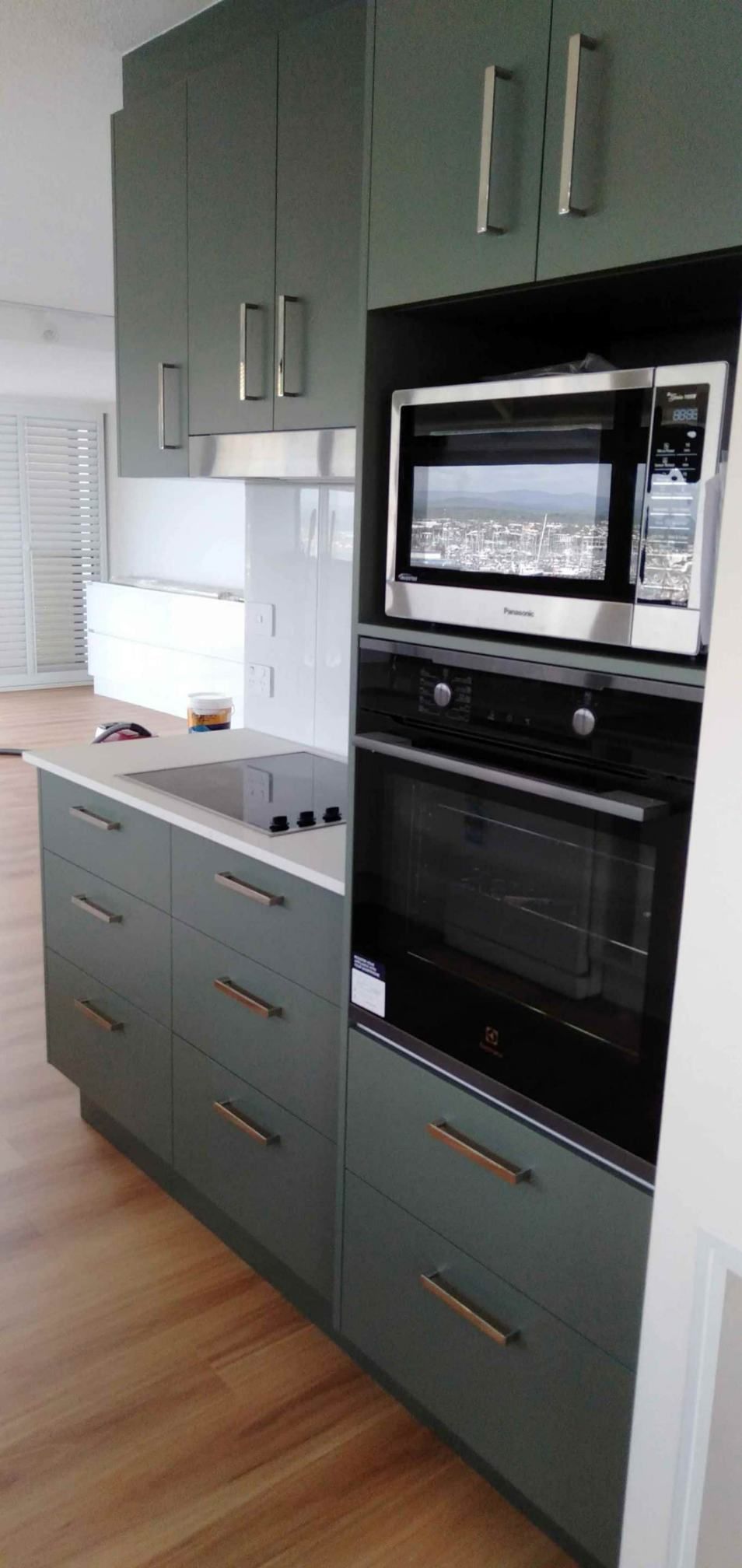 A Kitchen With Green Cabinets , And Microwave Oven — Nyblad Construction in Caloundra West, QLD