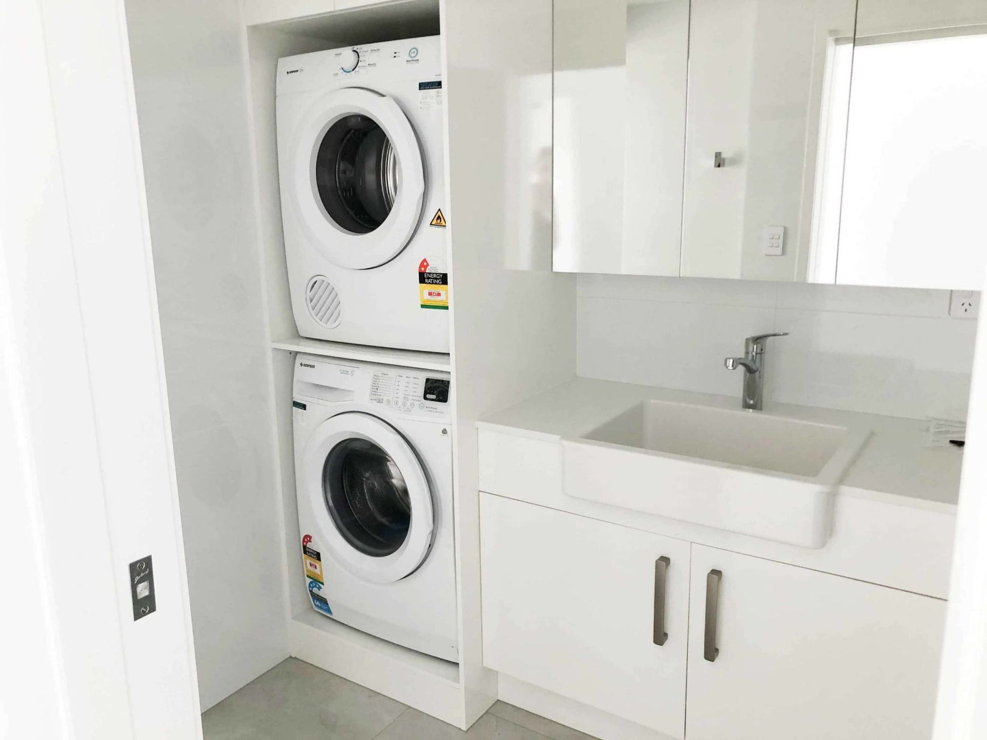 A Laundry Room With A Washer And Dryer Stacked On Top Of Each Other — Nyblad Construction in Caloundra West, QLD