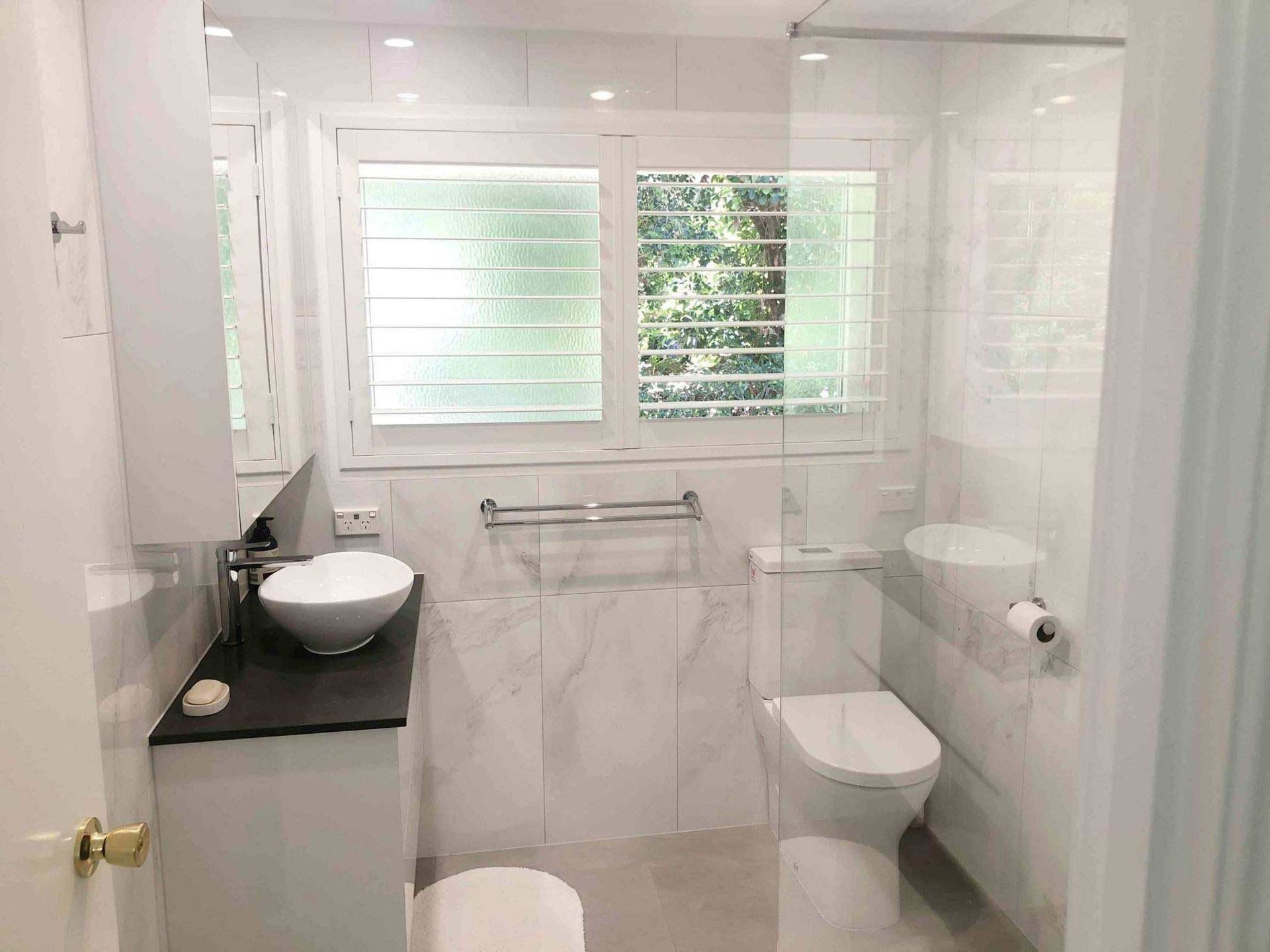 A Cozy Bathroom Featuring A Toilet, Sink, And Shower — Nyblad Construction in Caloundra West, QLD