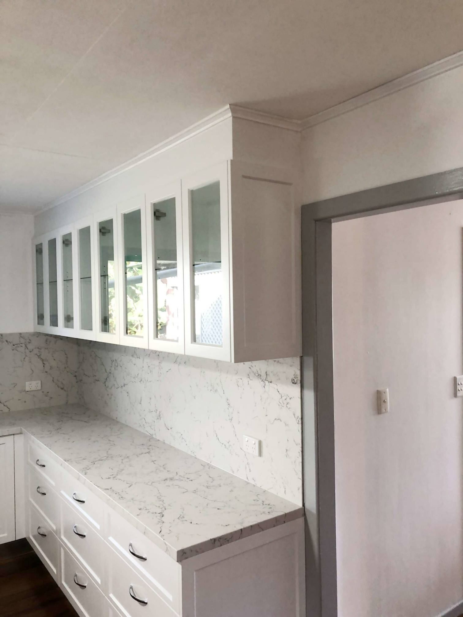 A Kitchen With White Cabinets And Marble Countertops — Nyblad Construction in Caloundra West, QLD