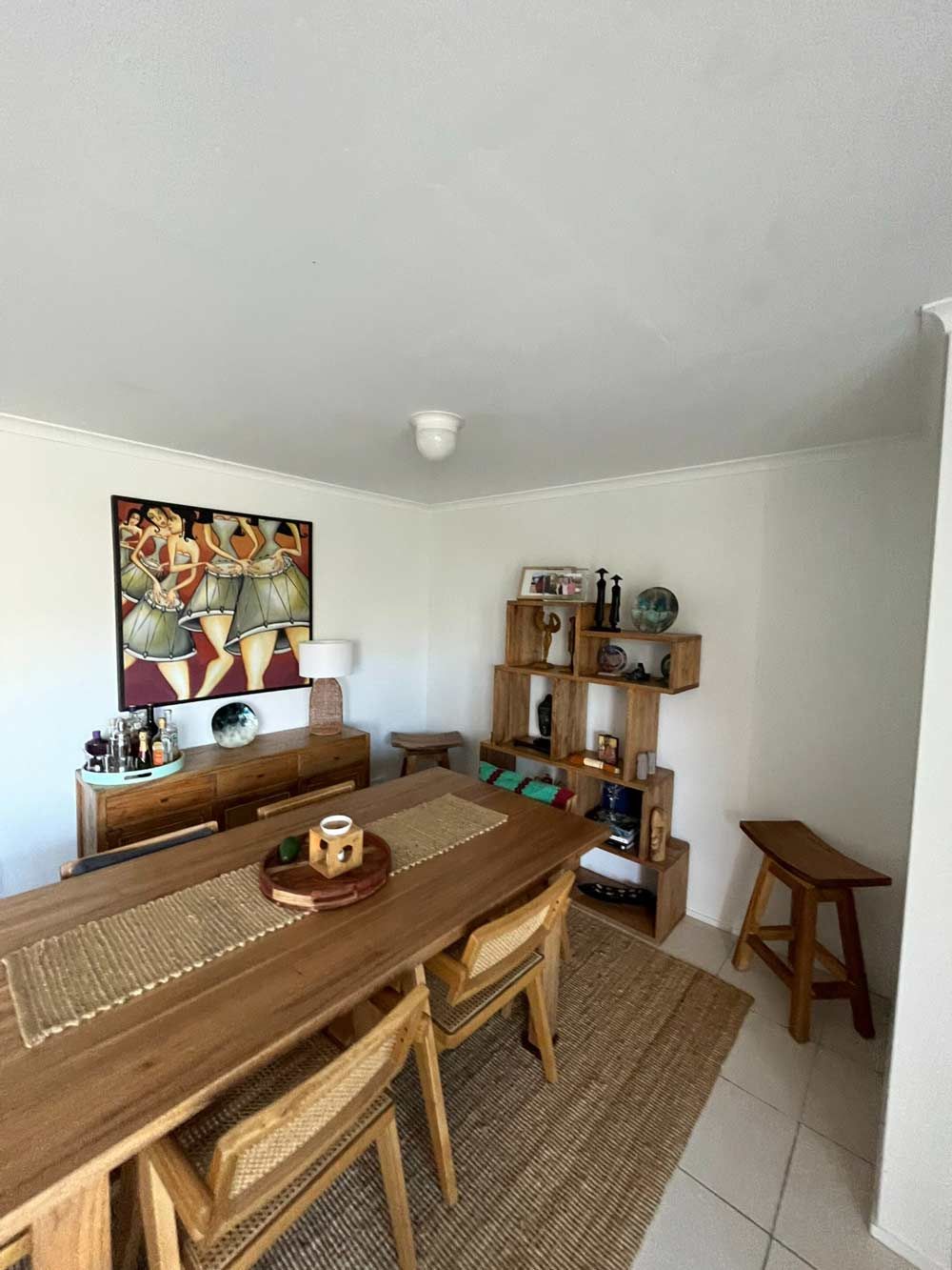 A Living Room With A Wooden Table And Chairs And A Painting On The Wall — Nyblad Construction in Caloundra West, QLD