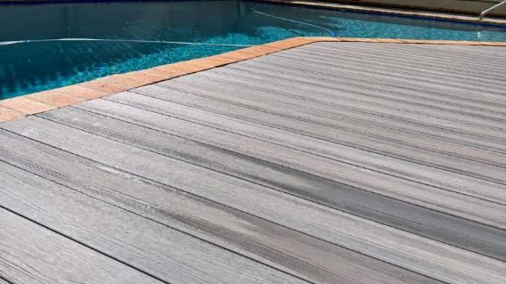 A Wooden Deck Next To A Swimming Pool — Nyblad Construction in Caloundra West, QLD
