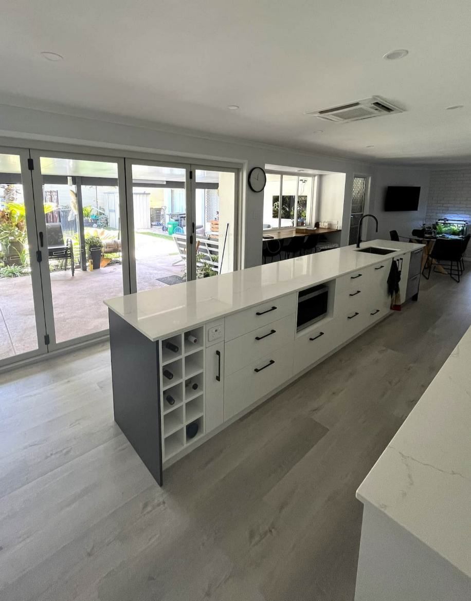 A Kitchen With White Cabinets And A Wine Rack On The Counter — Nyblad Construction in Caloundra West, QLD