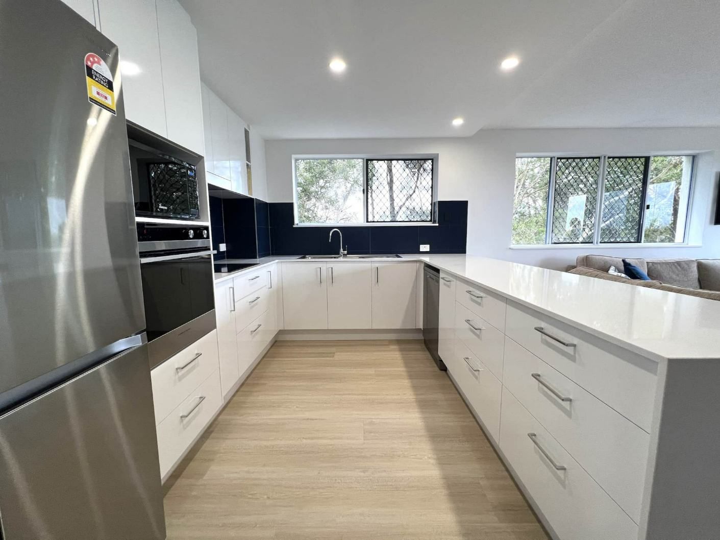 Stainless Steel Appliances And White Cabinets In The Kitchen — Nyblad Construction in Caloundra West, QLD