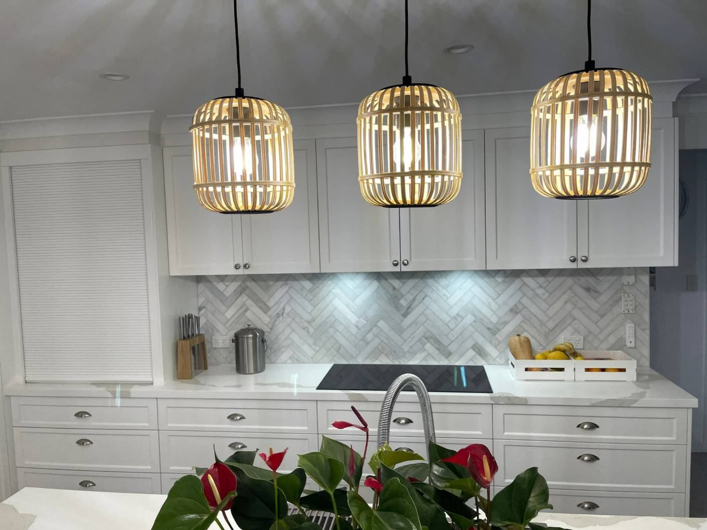 A Kitchen A Stove And Three Pendant Lights Hanging From The Ceiling — Nyblad Construction in Caloundra West, QLD