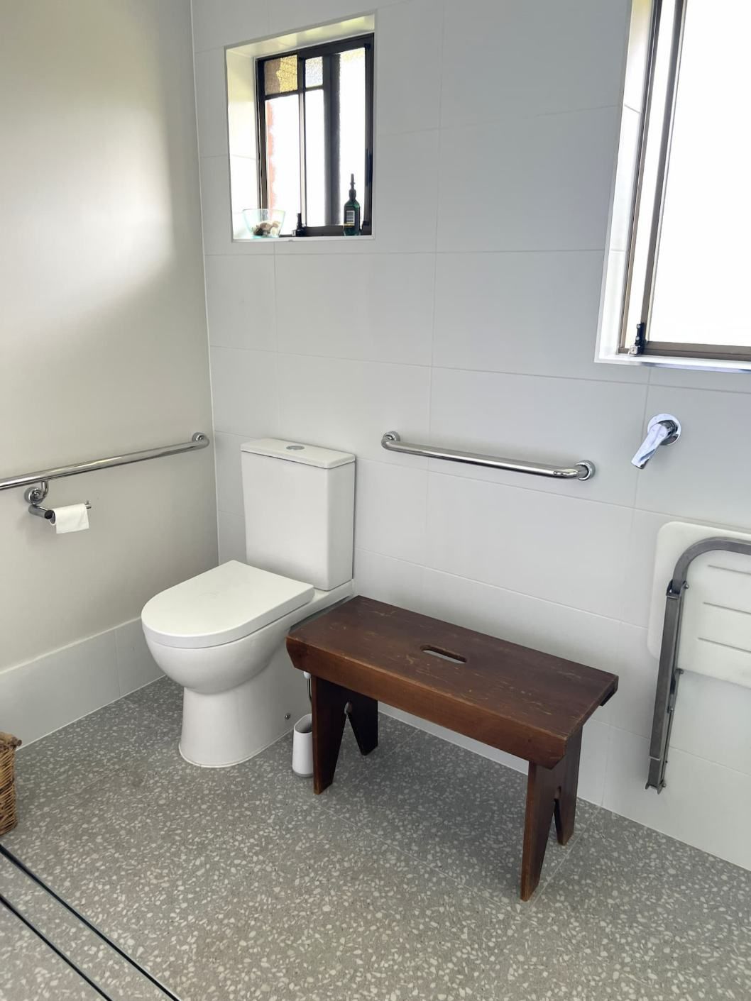 A Bathroom With A Toilet And A Small Wooden Bench — Nyblad Construction in Caloundra West, QLD