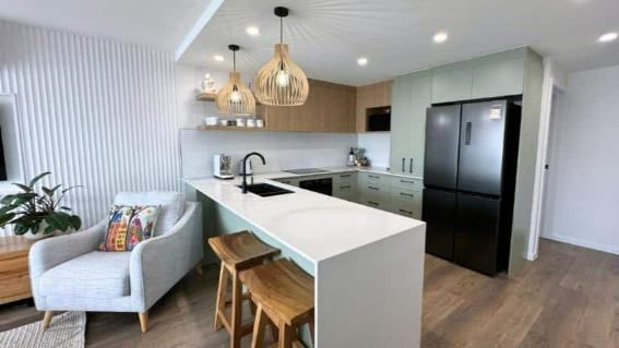 A Kitchen With A Couch And  Stools — Nyblad Construction in Caloundra West, QLD