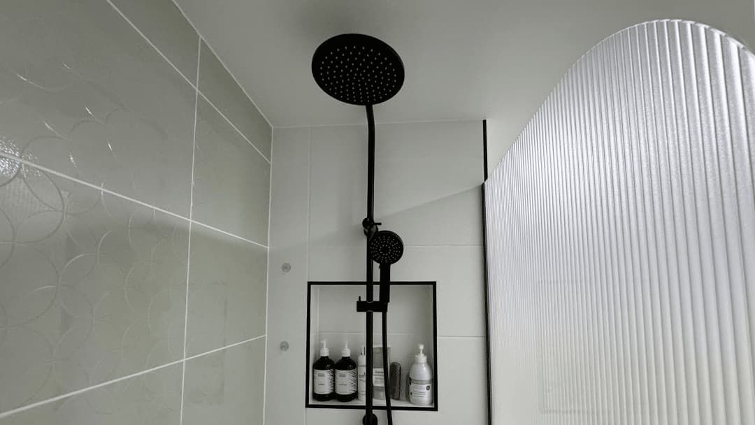 A Shower Head Is Hanging from The Ceiling in A Bathroom — Nyblad Construction in Caloundra West, QLD