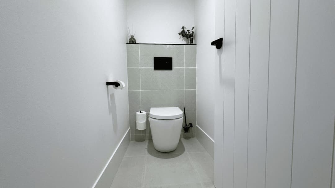 A Small Bathroom with A Toilet and A Brush on The Floor — Nyblad Construction in Caloundra West, QLD