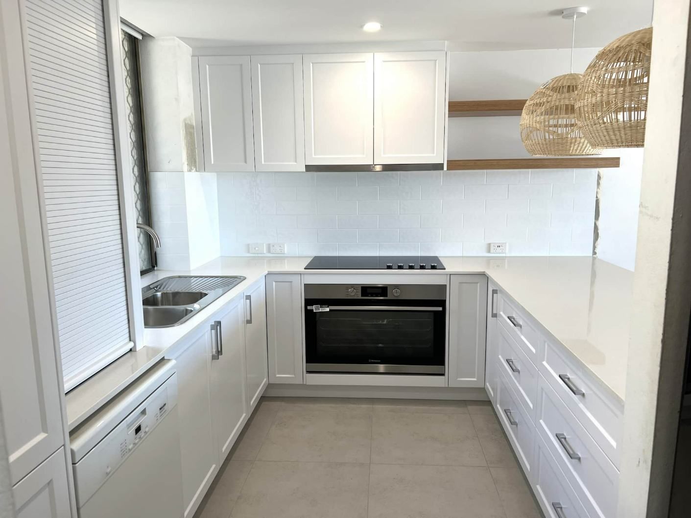 A Kitchen With White Cabinets, A Stove, A Sink, And A Dishwasher — Nyblad Construction in Caloundra West, QLD