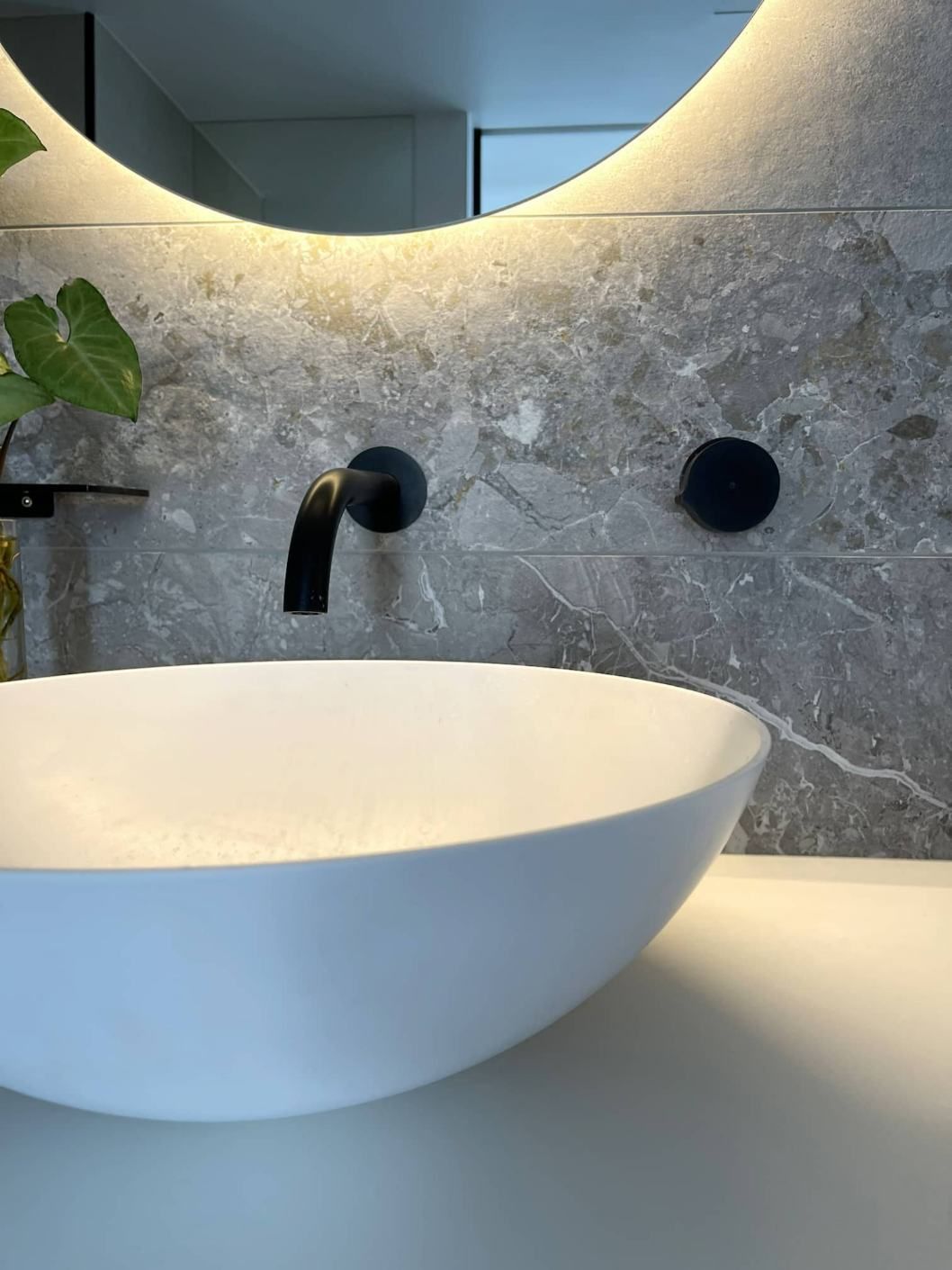 A Bathroom Sink With A Black Faucet And A Round Mirror — Nyblad Construction in Caloundra West, QLD