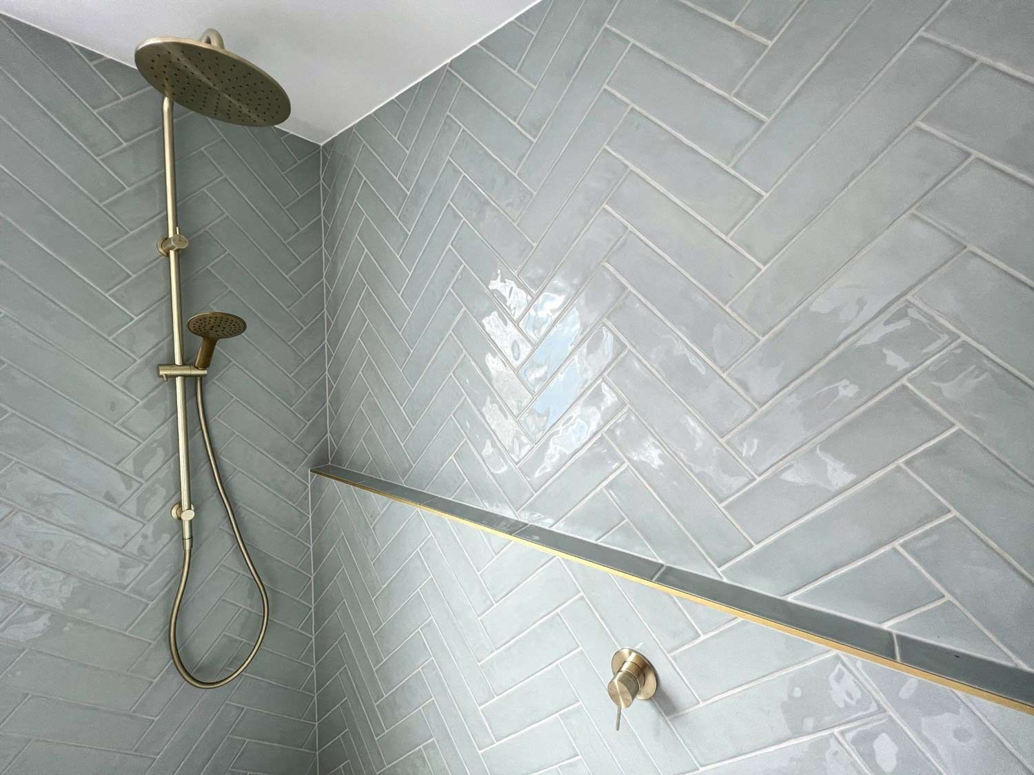 There Is A Shower Head In The Shower With A Herringbone Pattern On The Wall — Nyblad Construction in Caloundra West, QLD