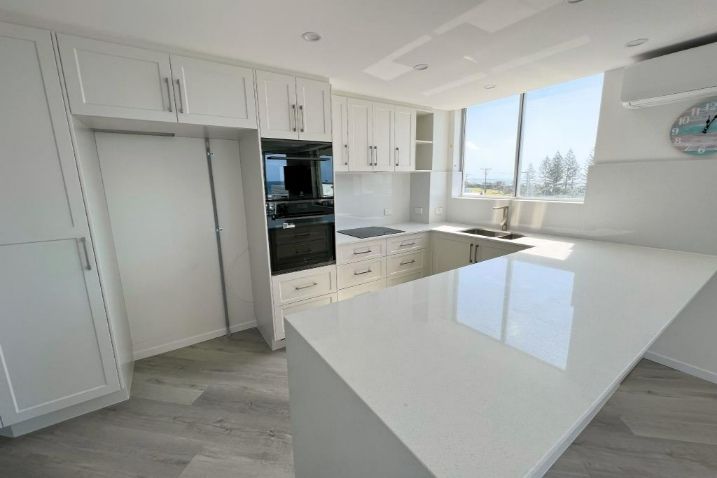 A Kitchen With White Cabinets, White countertops, And A Large Window — Nyblad Construction in Caloundra West, QLD