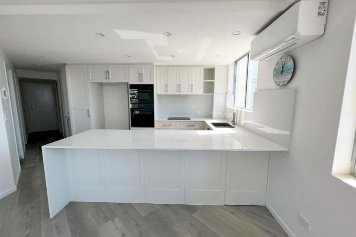  Kitchen Featuring White Cabinets And A Spacious Island — Nyblad Construction in Caloundra West, QLD