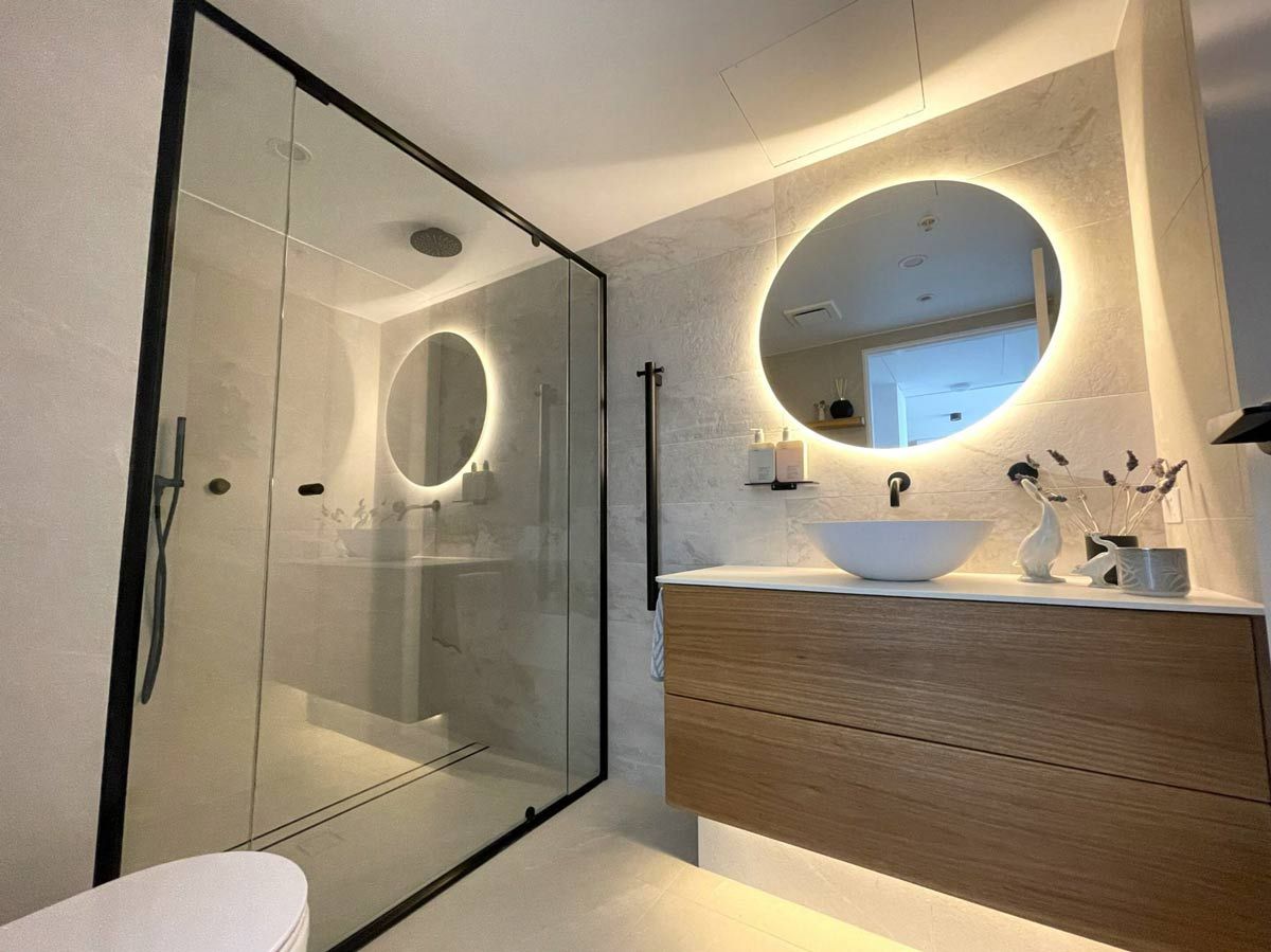 A Bathroom With A Toilet, Sink, Mirror And Shower — Nyblad Construction in Caloundra West, QLD