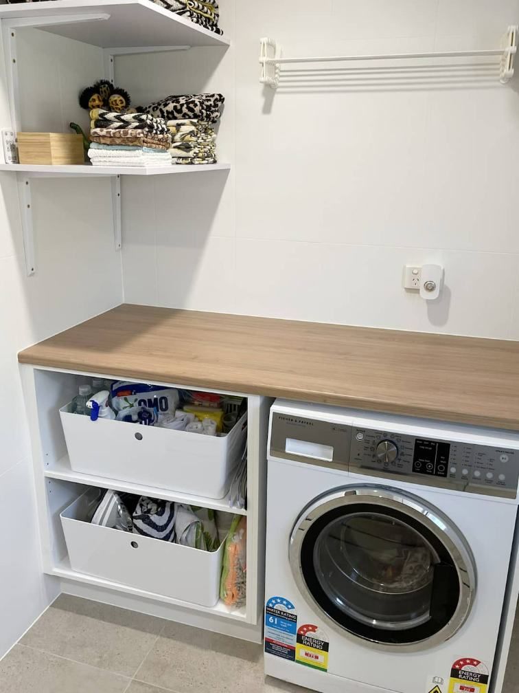 A Laundry Room With A Washing Machine And A Wooden Counter Top — Nyblad Construction in Caloundra West, QLD