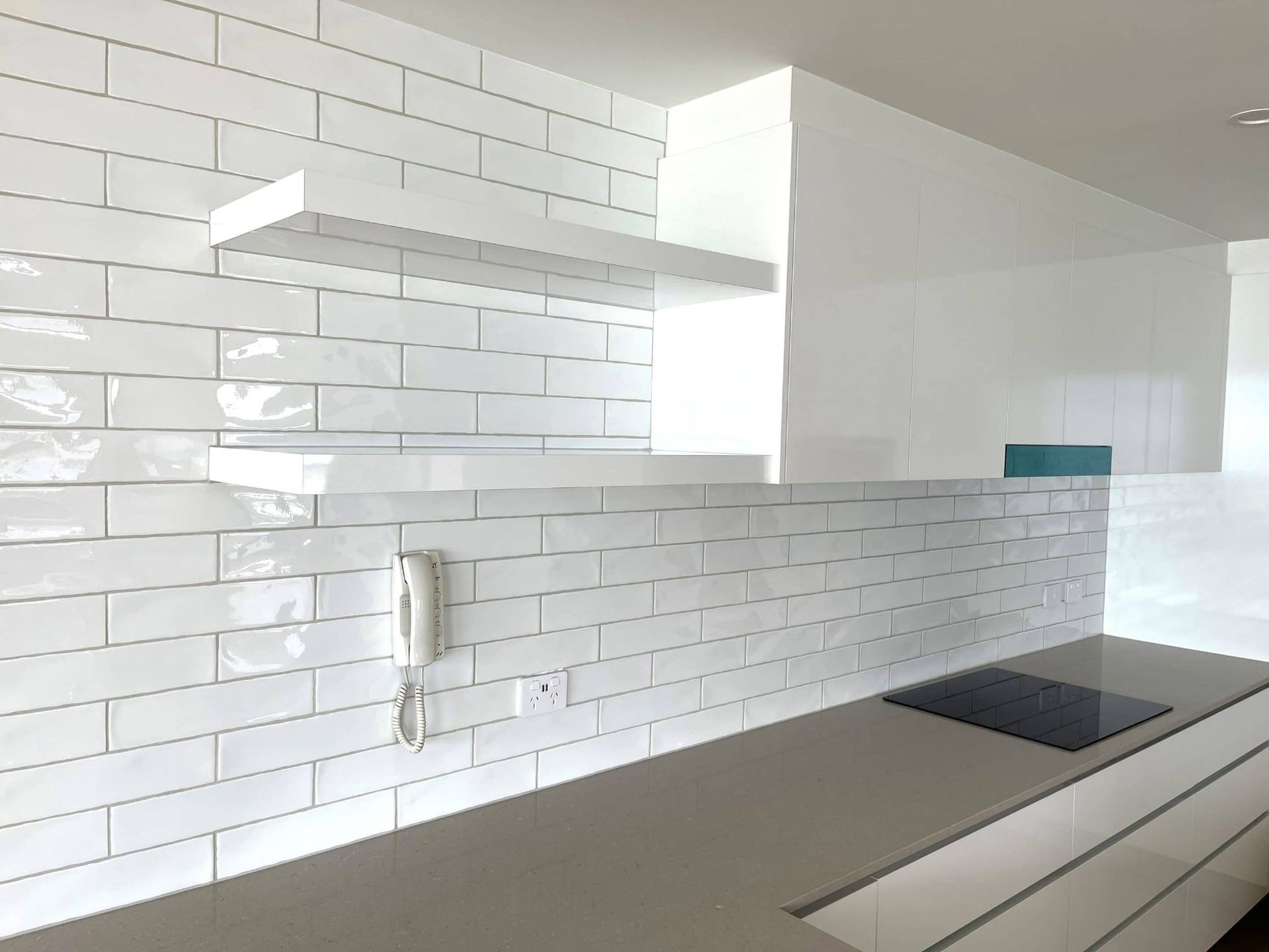 A Kitchen With White Subway Tiles And A Stove Top Oven — Nyblad Construction in Caloundra West, QLD