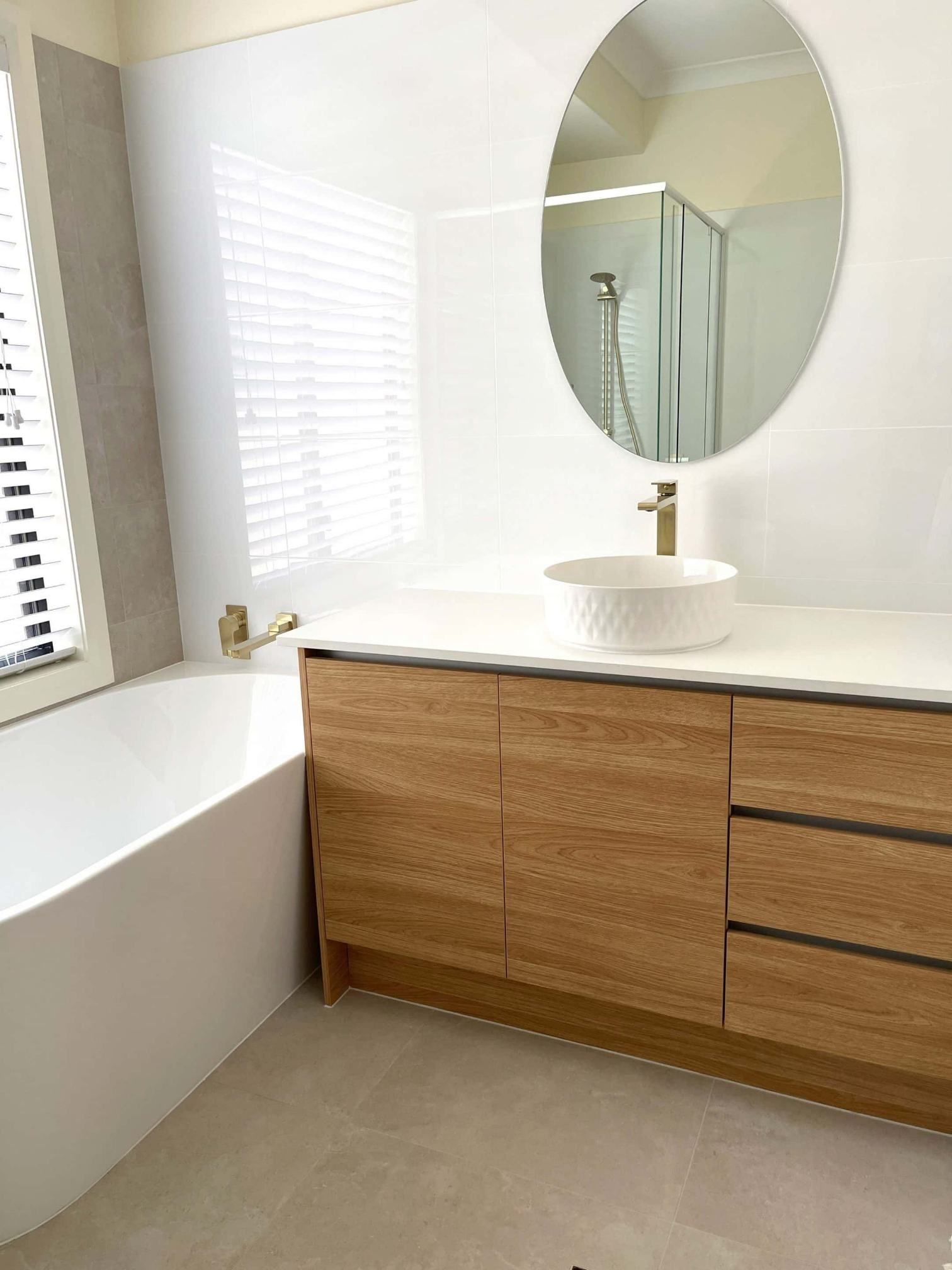 A Bathroom With a Round, Mirror And Bathtub — Nyblad Construction in Caloundra West, QLD