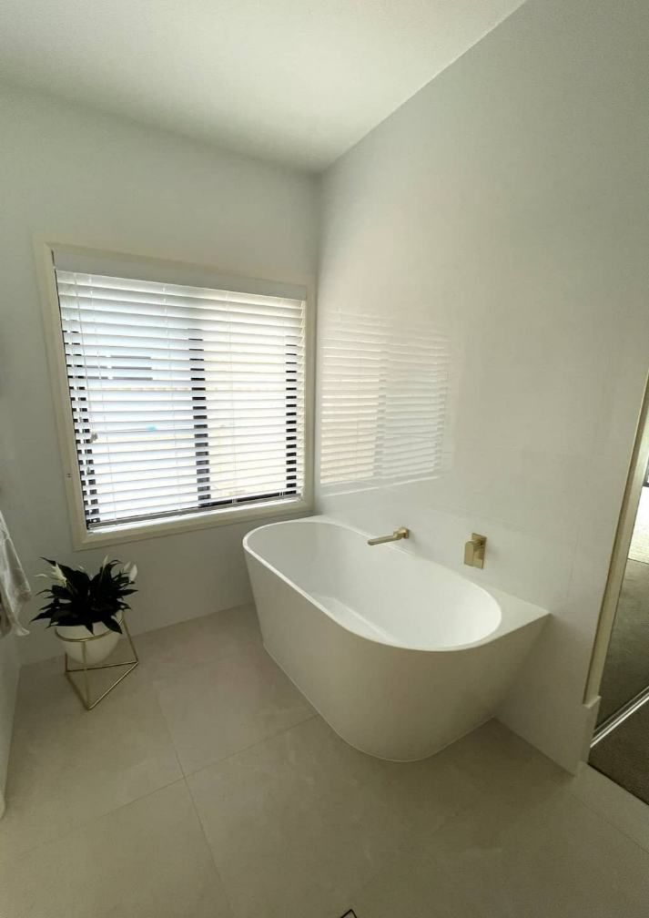 A Bathroom With A Bathtub And A Window — Nyblad Construction in Caloundra West, QLD