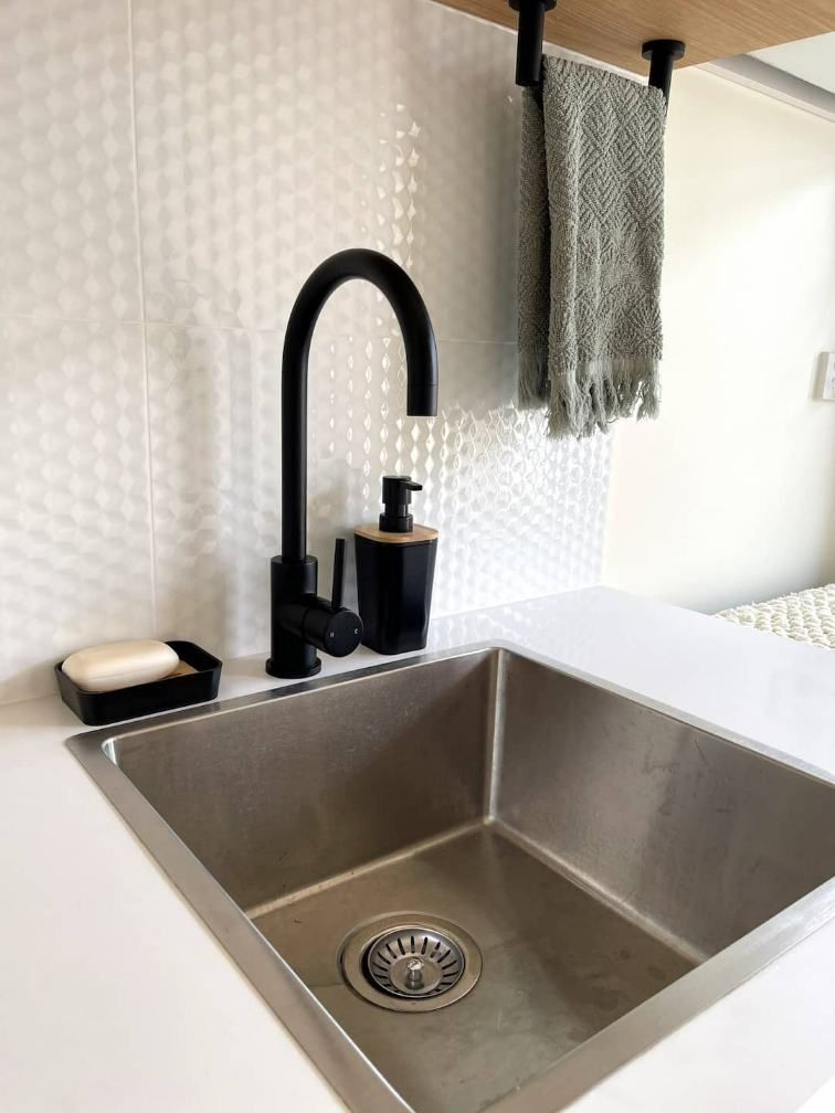 A Kitchen Sink With A Black Faucet And Soap Dispenser — Nyblad Construction in Caloundra West, QLD