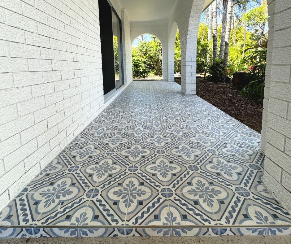 Porch With Patterned Blue And Grey Tiles, White Brick Wall, And Arched Columns — Nyblad Construction in Caloundra West, QLD