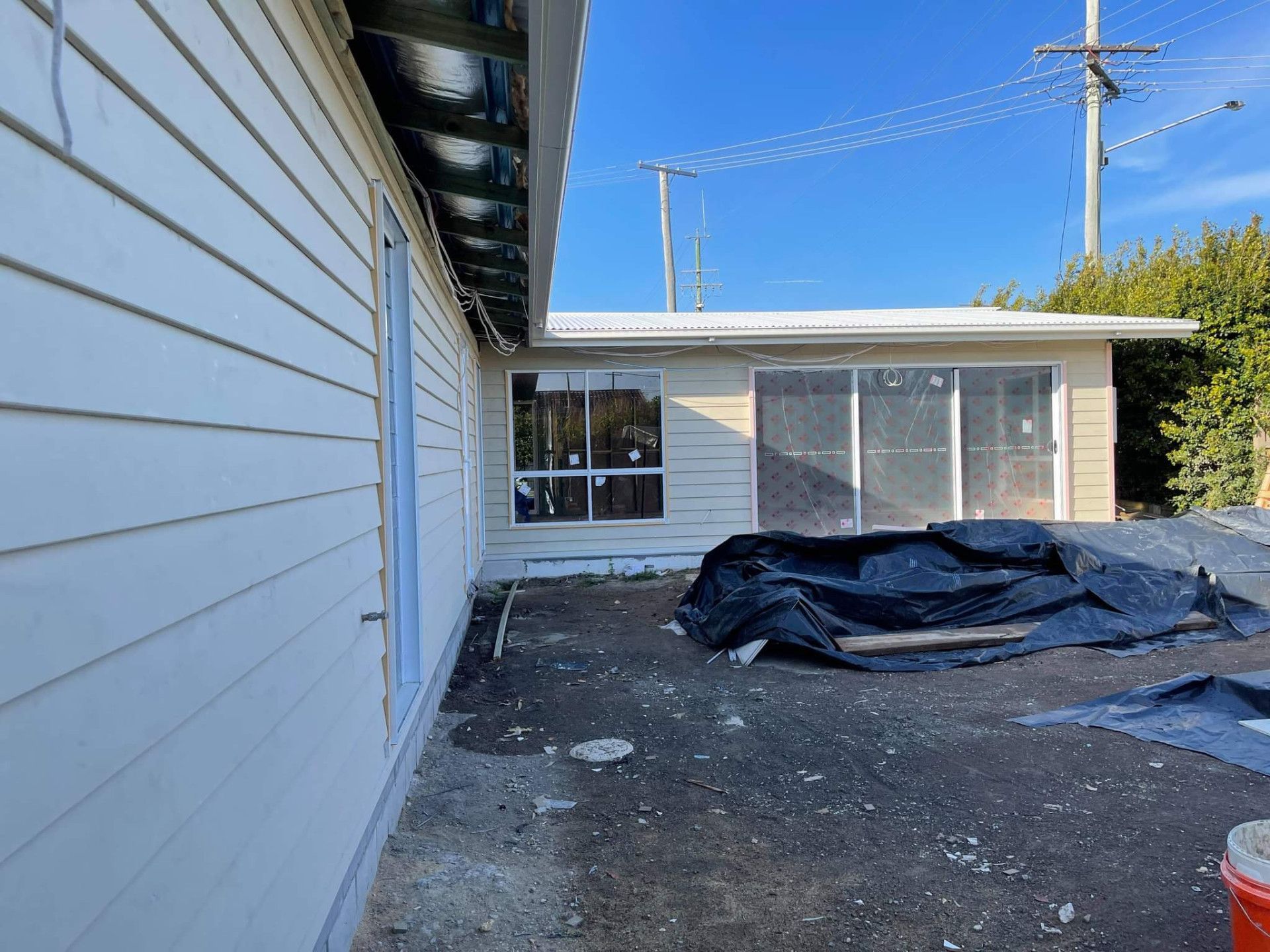 Exterior of a house under construction; siding, windows, and tarp on the ground. — Nyblad Construction in Coolum, QLD