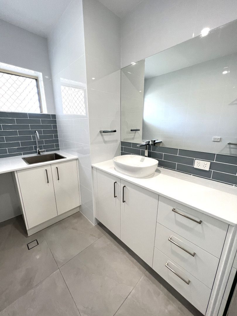 Modern, bright bathroom with white cabinets, gray tile backsplash, and large mirror. — Nyblad Construction in Coolum, QLD