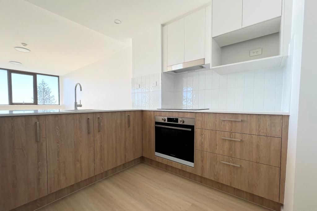 Empty Kitchen With Wooden Cabinets — Nyblad Construction in Caloundra West, QLD
