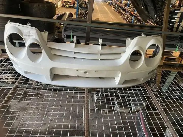 A White Bumper Is Sitting On Top Of A Metal Grid — Bago Auto Dismantlers in Laurieton, NSW