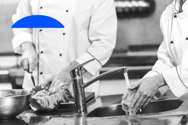 Deux chefs se lavent les mains dans un évier de cuisine.