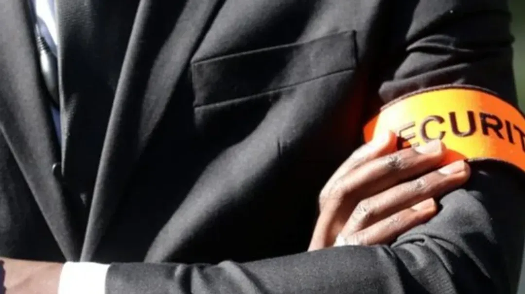 Un homme en costume porte un brassard de sécurité au bras