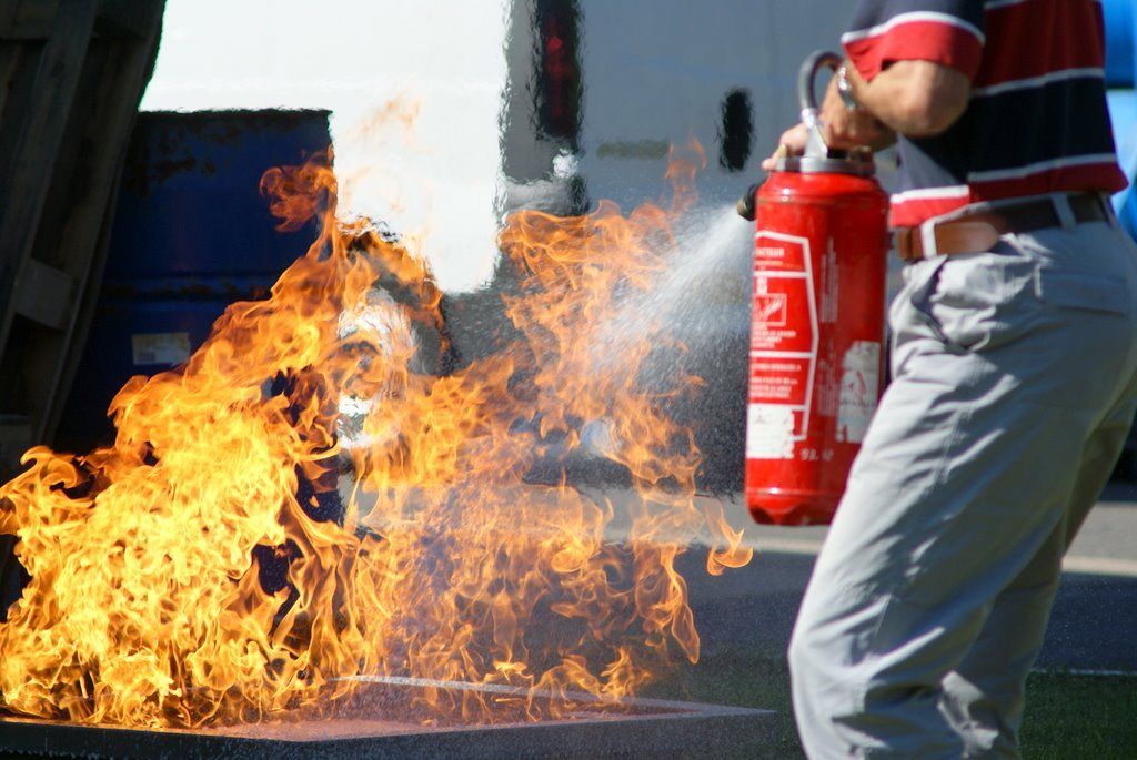 Un homme utilise un extincteur pour éteindre un incendie
