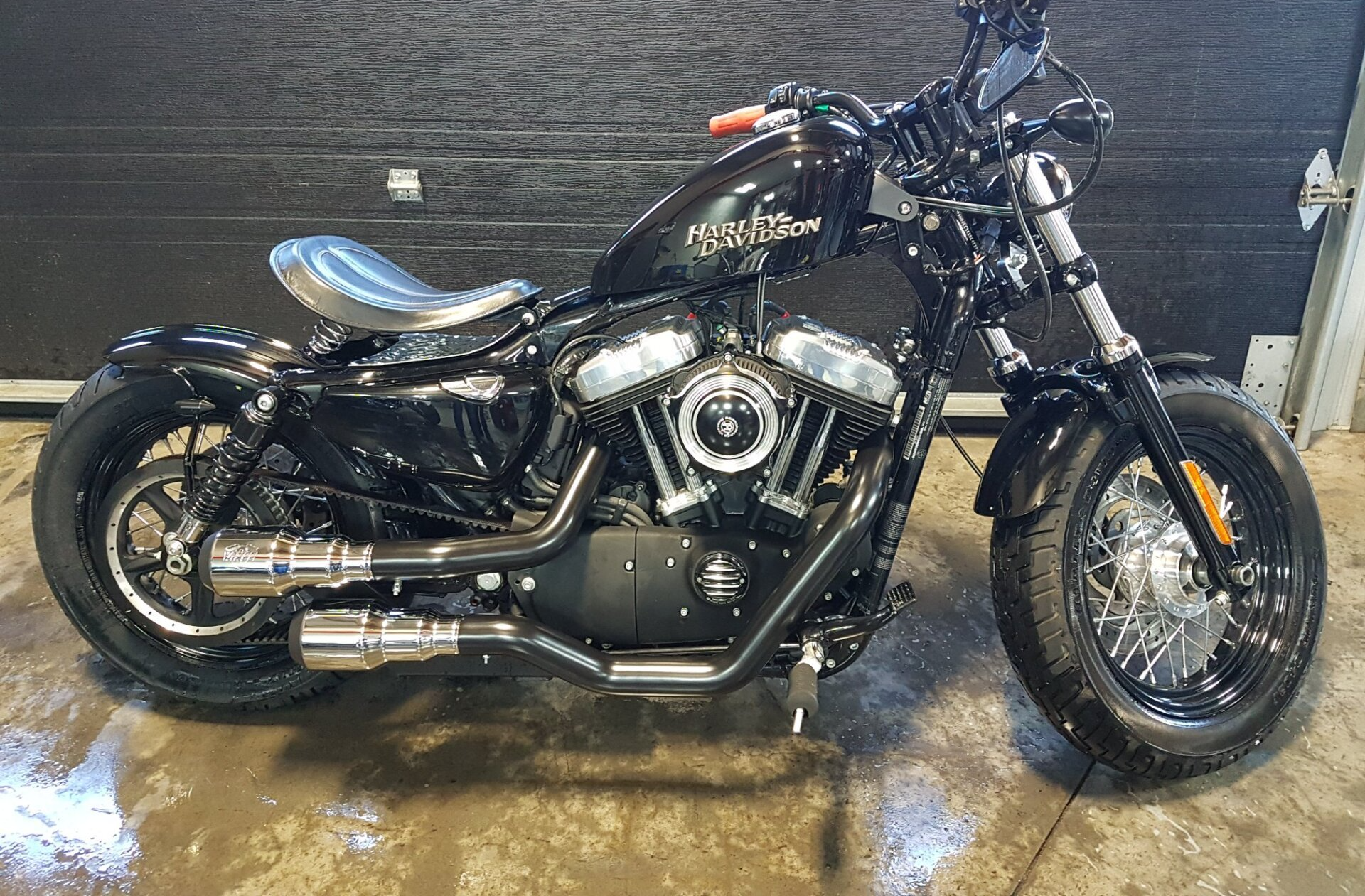 Moto Harley Davidson noire, accents chromés, selle solo personnalisée, réglage garage.
