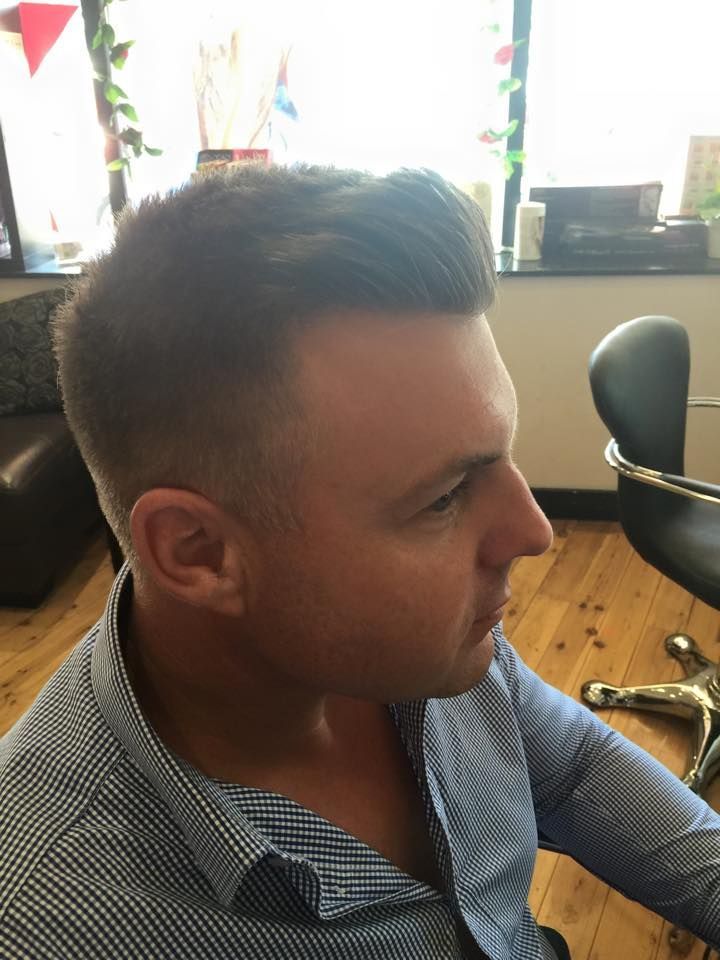 A Man in a Blue Shirt is Sitting in a Chair in a Room — Elysian Salon In Wyong, NSW