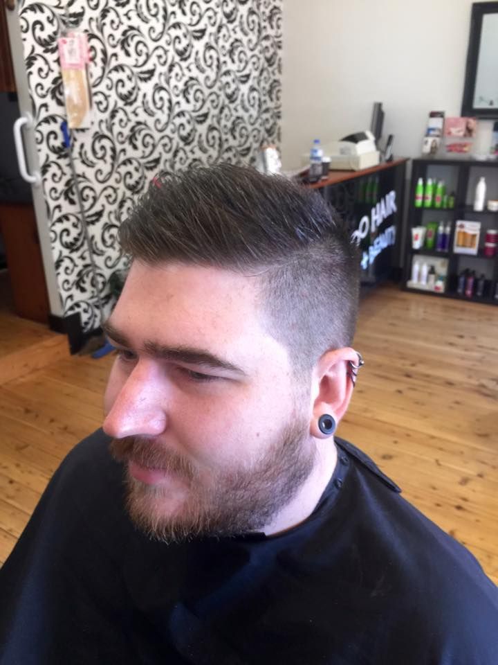 A Man With a Beard is Getting His Hair Cut at a Barber Shop — Elysian Salon In Wyong, NSW
