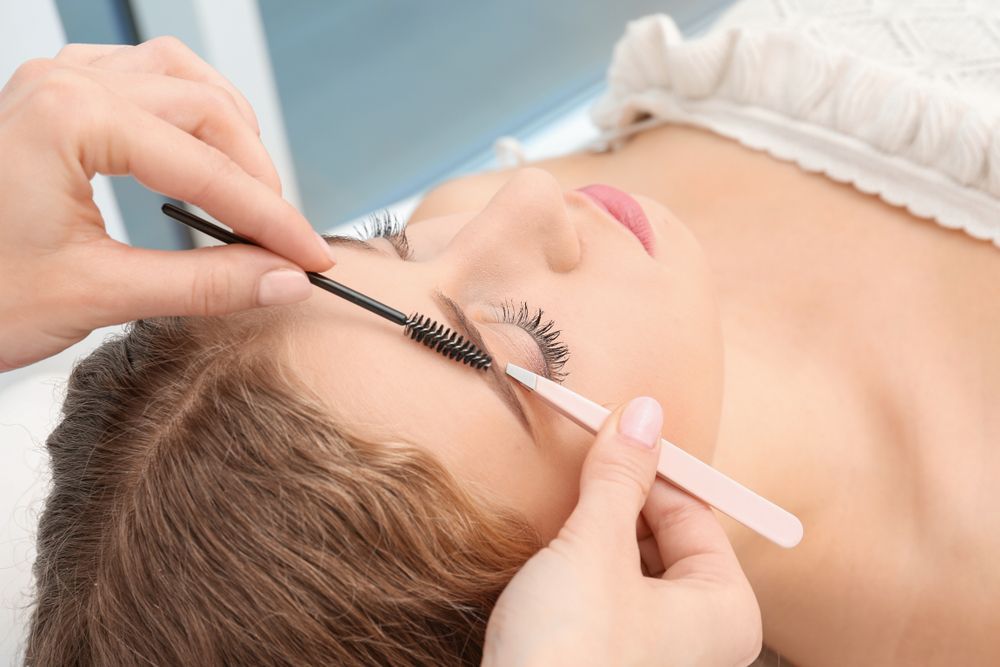 A Woman Lying Down In A Salon Getting Facial Tinting Treatment — Elysian Salon In Wyong, NSW