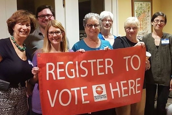 Group of WDC members holding a red 