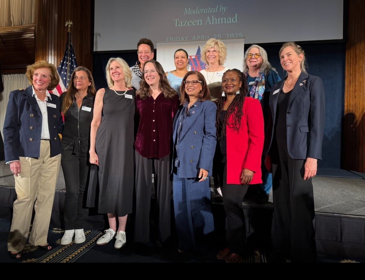A group of WDC members from a WDC sponsored event with the WDC logo in the background