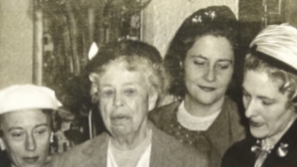 A black and white photo of Eleanor Roosevelt attending a WDC meeting