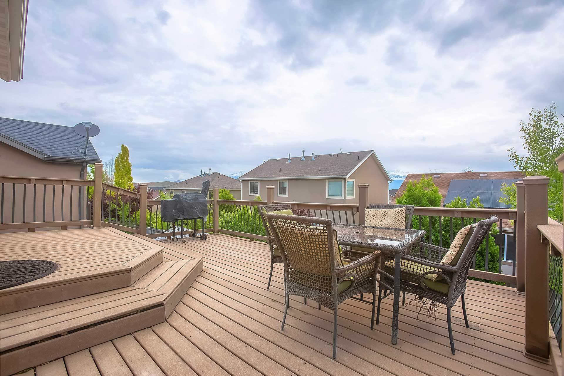 Wicker glass table and wicker chairs with cushions on the balcony of a home
