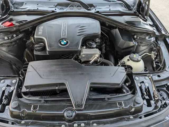 BMW engine bay with black air intake and open hood | JC Auto Repair LLC