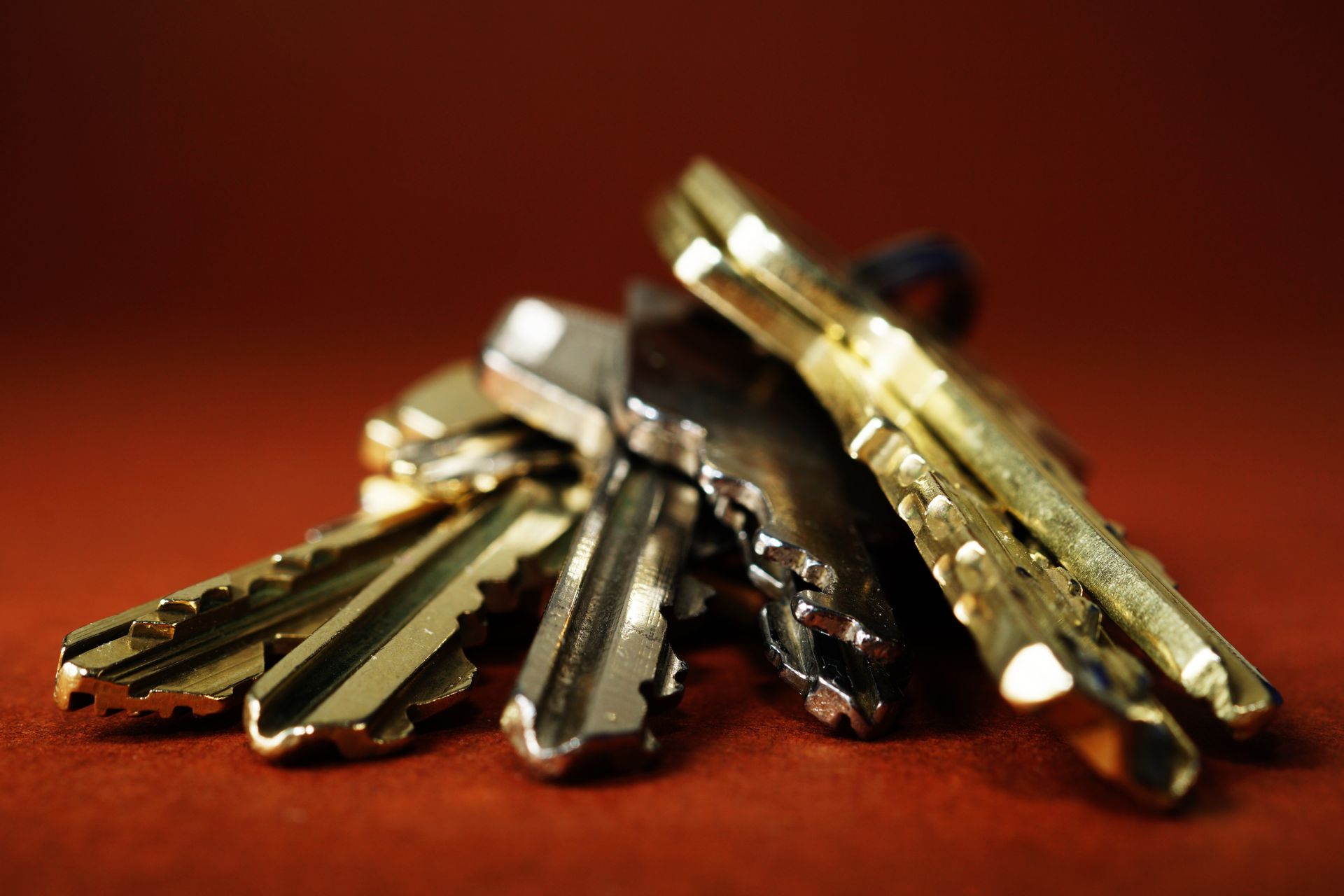 A small bunch of keys, varying in color, resting on a brown surface.