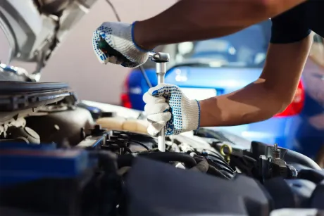 Mechanic tightening a bolt in a car engine with a socket wrench